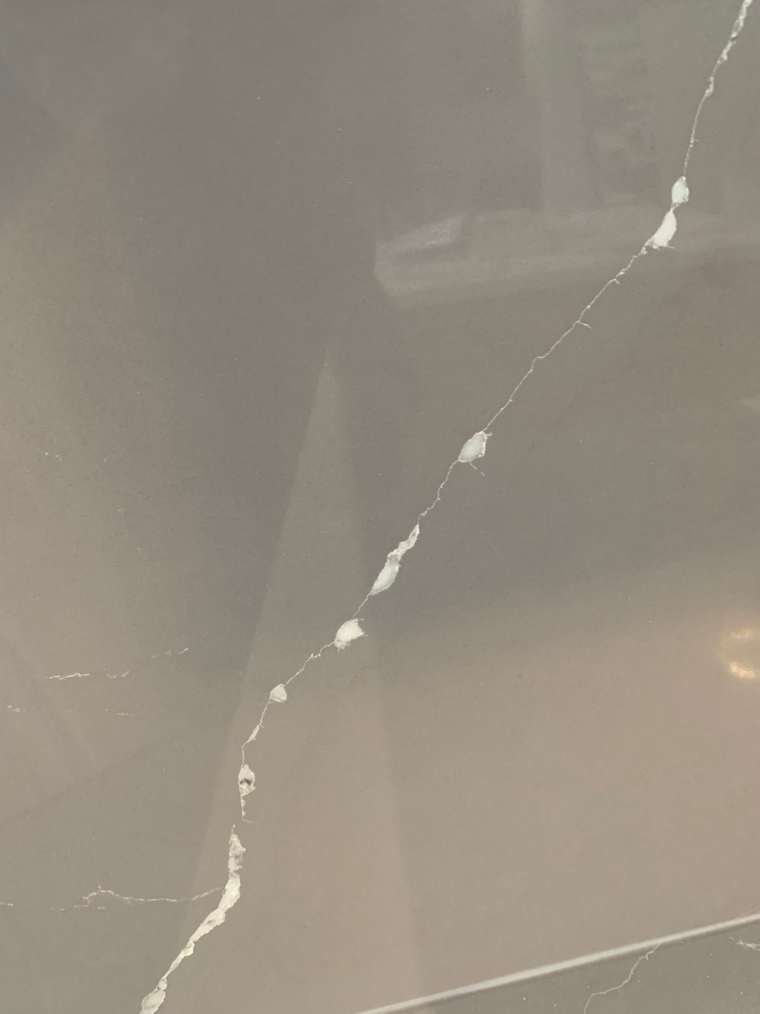 Taupe quartz slab with refined white veining close-up texture